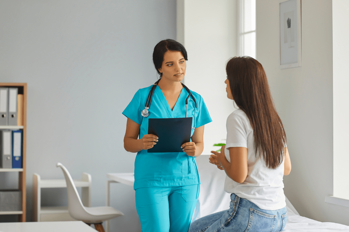 Medical Services page Nurse speaking to woman in clinic